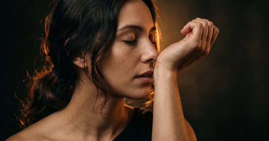 A person raising their wrist to their nose searching for their perfume scent — illustrating olfactory fatigue